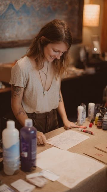 Guest smiling as she writes a card at a table